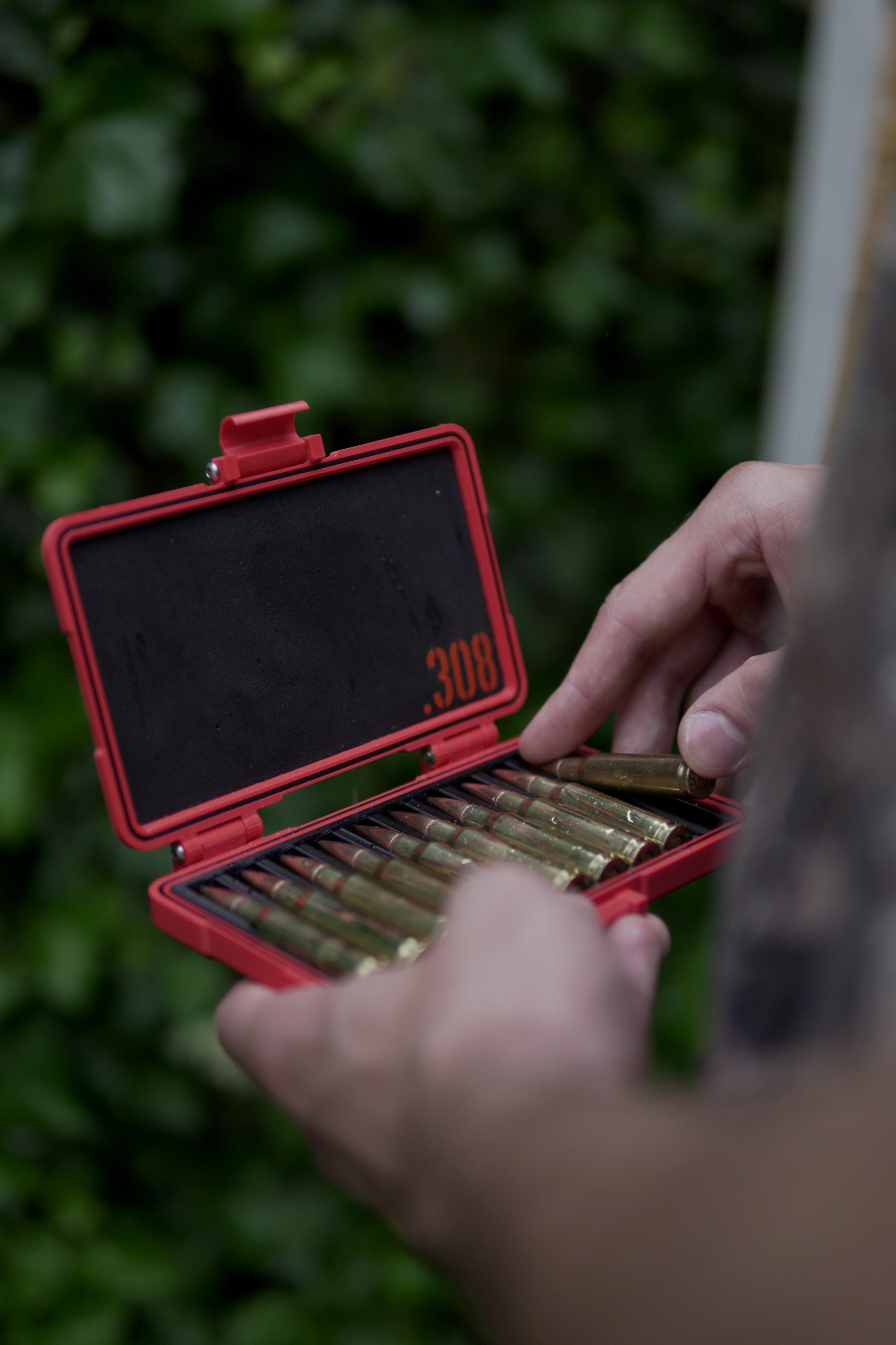 Person håller ammunitionlåda med naturmotiv